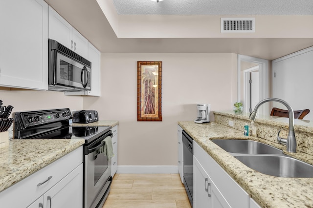 kitchen featuring appliances with stainless steel finishes, white cabinets, visible vents, and a sink