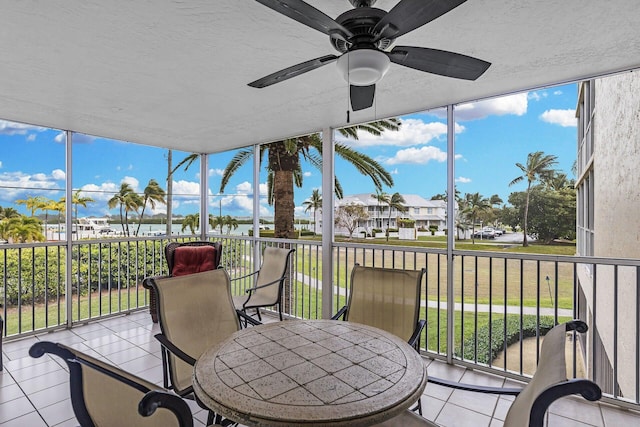 sunroom with ceiling fan and a residential view