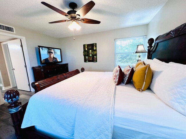 bedroom with a textured ceiling, ceiling fan, and visible vents