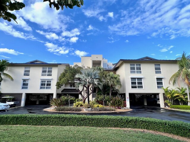 view of building exterior with a carport and aphalt driveway