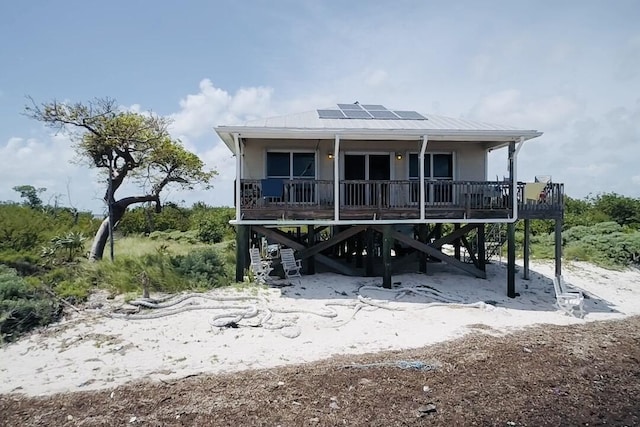 1W Cooks Is, Big Pine, FL 33043 - view of front of home with a porch, solar panels, stairs, and a metal roof