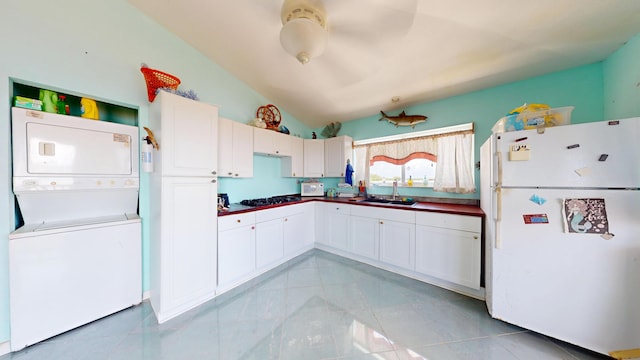 1W Cooks Is, Big Pine, FL 33043 - kitchen featuring freestanding refrigerator, stacked washer / drying machine, vaulted ceiling, white cabinets, and dark countertops