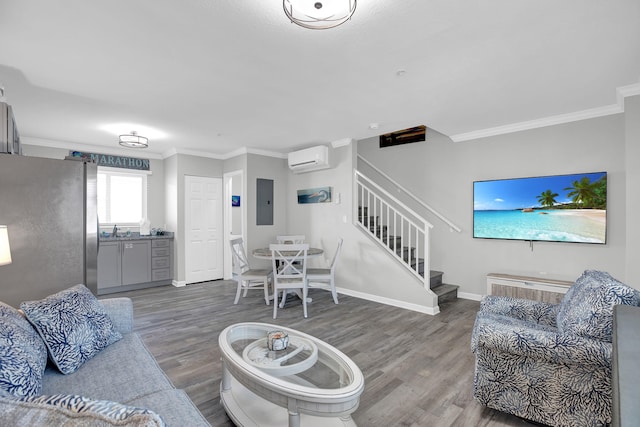 living room with stairway, ornamental molding, wood finished floors, a wall mounted air conditioner, and electric panel