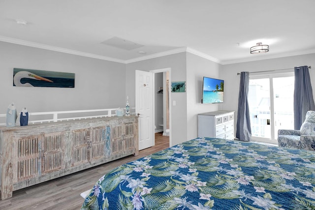 bedroom with ornamental molding and wood finished floors