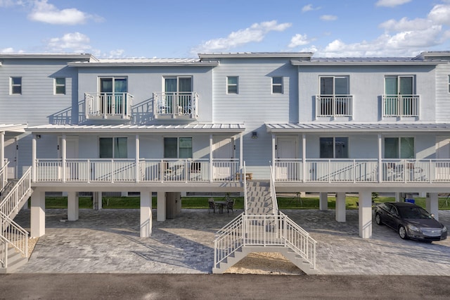 view of front of house with stairway and metal roof