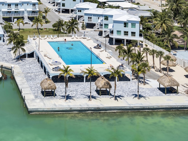 pool featuring a water view, fence, a gazebo, a residential view, and a patio area