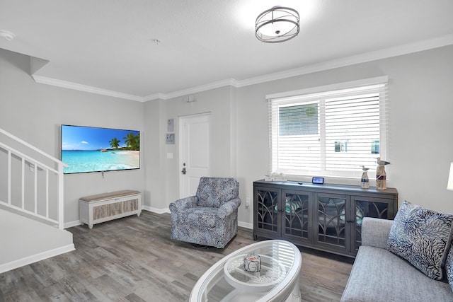 living area featuring crown molding, stairs, baseboards, and wood finished floors