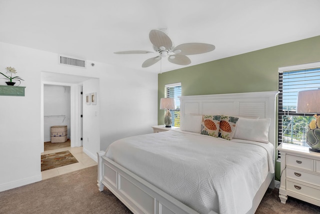 carpeted bedroom with a ceiling fan, visible vents, and baseboards