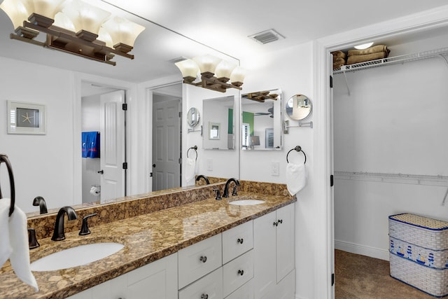 full bath featuring a walk in closet, visible vents, and a sink