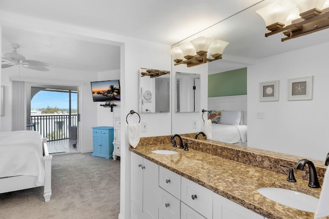 ensuite bathroom with ceiling fan, connected bathroom, a sink, and double vanity