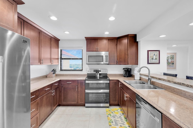 kitchen featuring light stone counters, recessed lighting, appliances with stainless steel finishes, light tile patterned flooring, and a sink