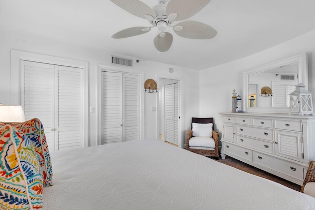 bedroom featuring a ceiling fan, visible vents, and two closets