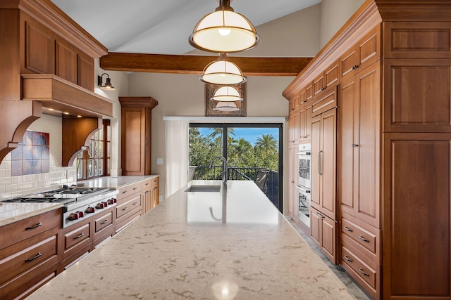 kitchen with stainless steel appliances, tasteful backsplash, brown cabinetry, a sink, and light stone countertops