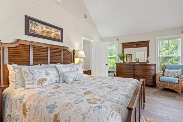 7202 Simran Ln, Duck, FL 33050 - bedroom featuring multiple windows, light wood-type flooring, and high vaulted ceiling