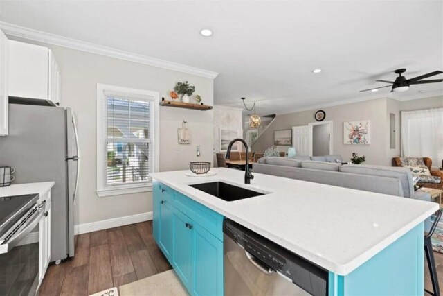 7202 Simran Ln, Duck, FL 33050 - kitchen with appliances with stainless steel finishes, blue cabinetry, open floor plan, crown molding, and dark wood finished floors