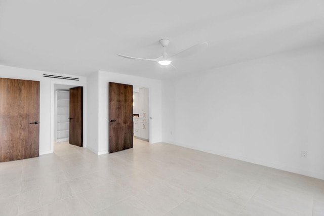 spare room with visible vents, ceiling fan, and baseboards