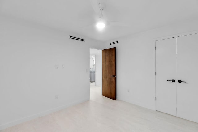 unfurnished bedroom with visible vents, baseboards, and a closet