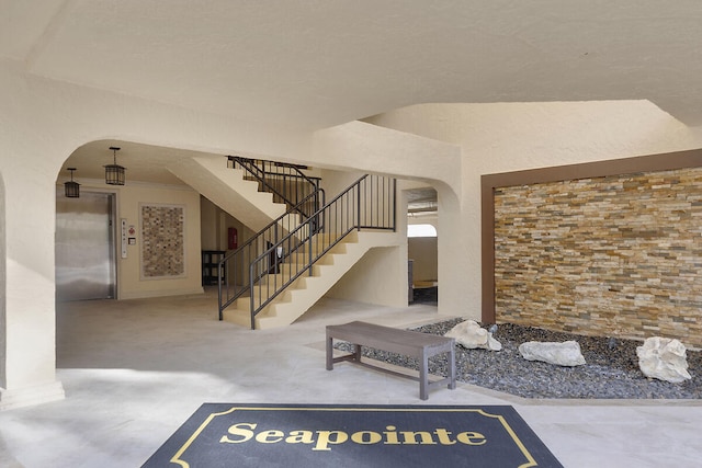 stairway featuring arched walkways