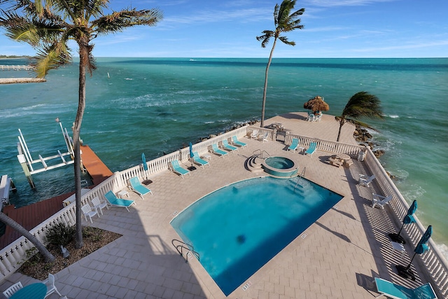 exterior space featuring a water view, a patio area, and fence
