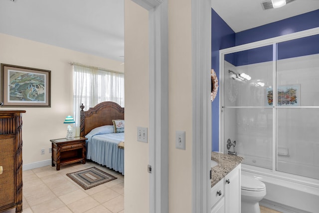 interior space featuring enclosed tub / shower combo, toilet, vanity, tile patterned floors, and ensuite bath