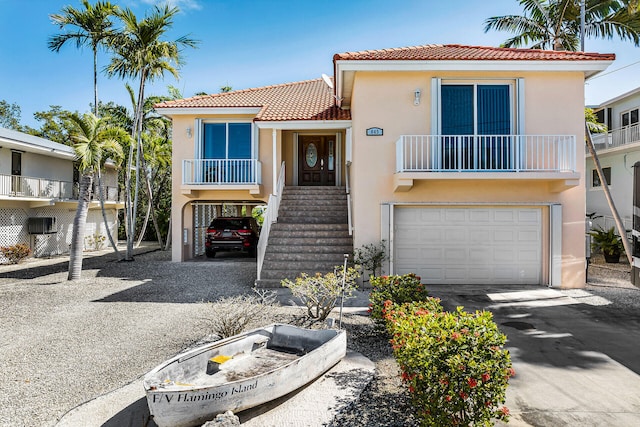 view of front of house featuring a tile roof, stucco siding, an attached garage, a carport, and driveway