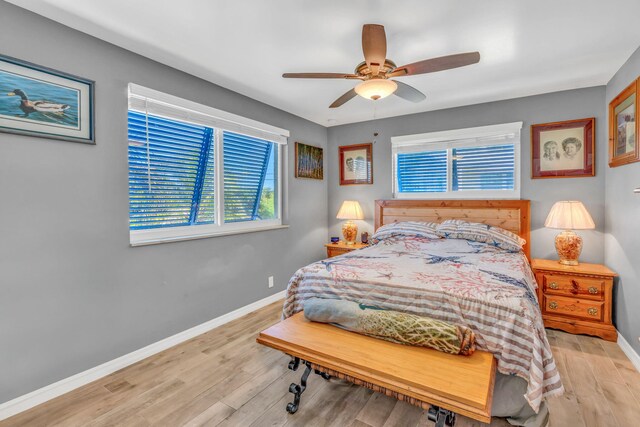 bedroom featuring a ceiling fan, baseboards, and wood finished floors