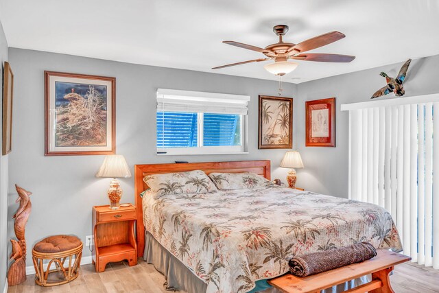 bedroom with light wood-style floors, baseboards, and a ceiling fan