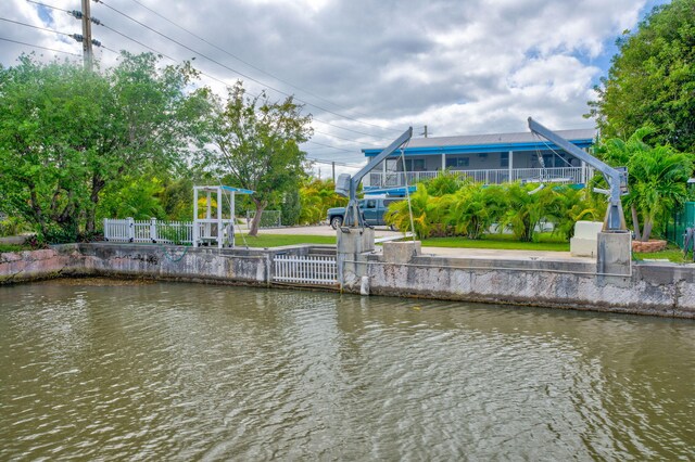 view of dock with a water view and fence