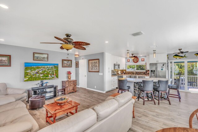 living area with recessed lighting, visible vents, ceiling fan, and light wood-style flooring