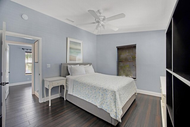 bedroom featuring ceiling fan, dark wood-type flooring, and baseboards