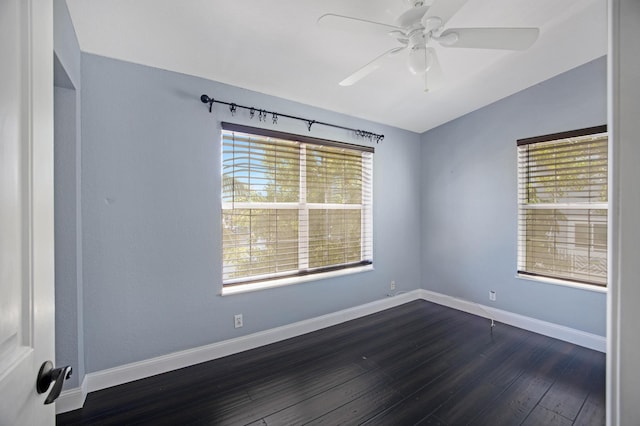 unfurnished room featuring a ceiling fan, plenty of natural light, baseboards, and dark wood-style flooring