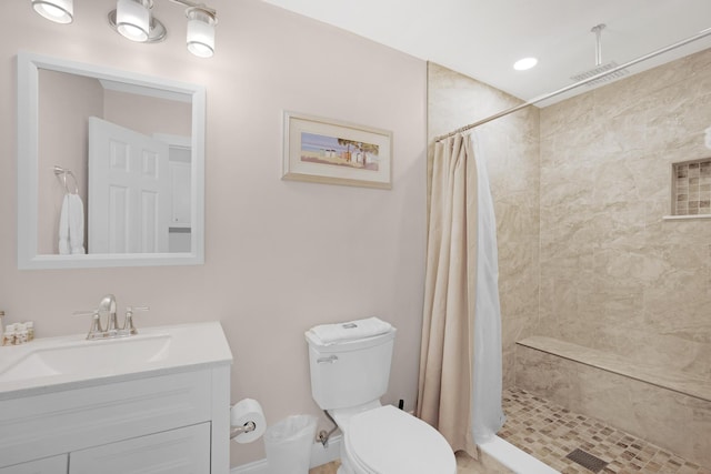 full bath featuring visible vents, vanity, a shower stall, and toilet