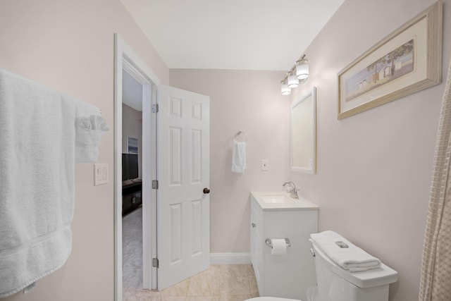 bathroom featuring toilet, baseboards, and vanity