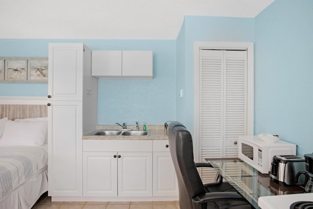 interior space with a closet, a sink, and light tile patterned flooring