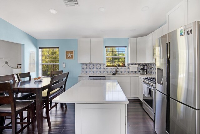 kitchen featuring appliances with stainless steel finishes, white cabinets, visible vents, and a kitchen island