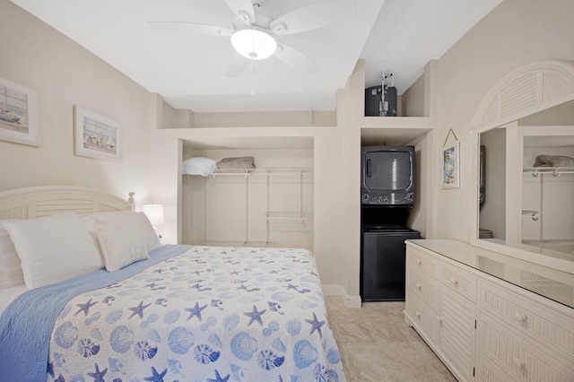 bedroom with ceiling fan and stacked washer and dryer