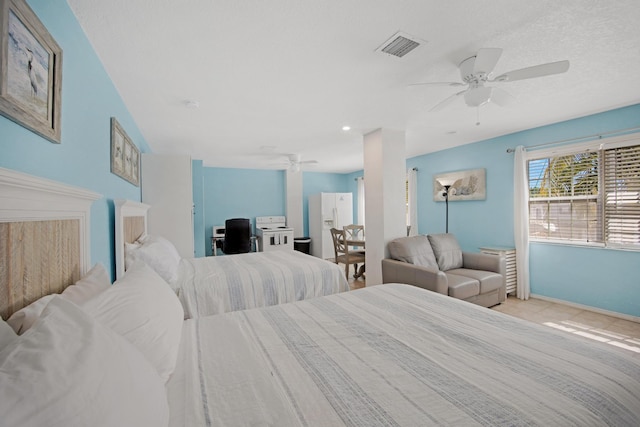 bedroom with ceiling fan, white refrigerator with ice dispenser, visible vents, and baseboards