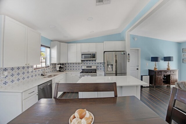 kitchen featuring stainless steel appliances, white cabinets, light countertops, and a sink