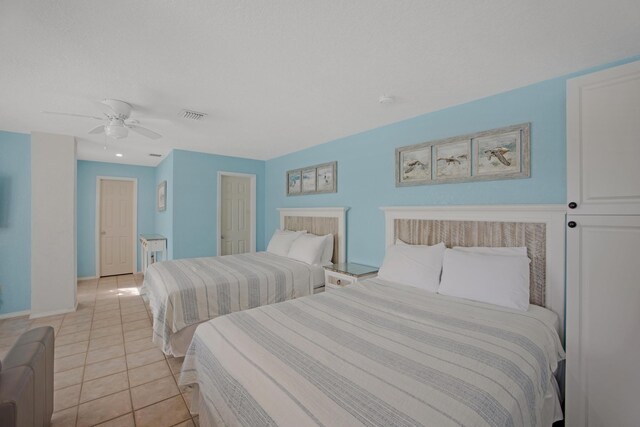 bedroom with a ceiling fan, visible vents, baseboards, and light tile patterned floors