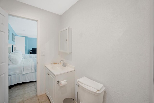 bathroom featuring tile patterned flooring, vanity, toilet, and ensuite bathroom