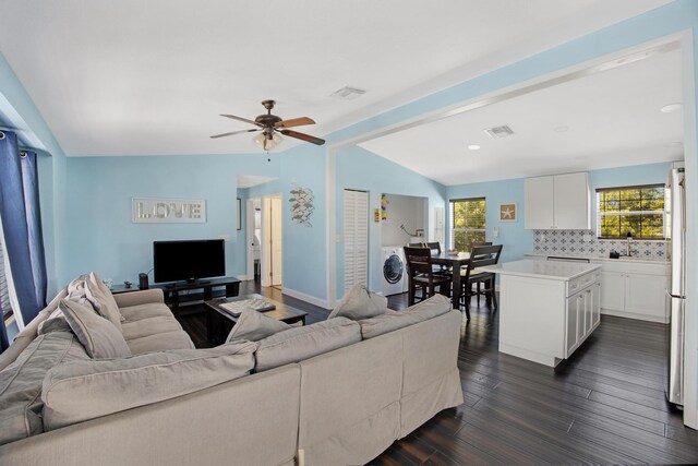 living room with washer / clothes dryer, visible vents, vaulted ceiling with beams, and dark wood-style flooring