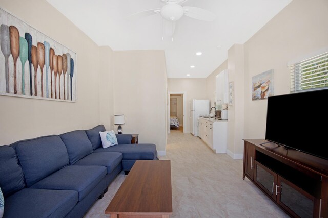 living area with baseboards, a ceiling fan, and recessed lighting