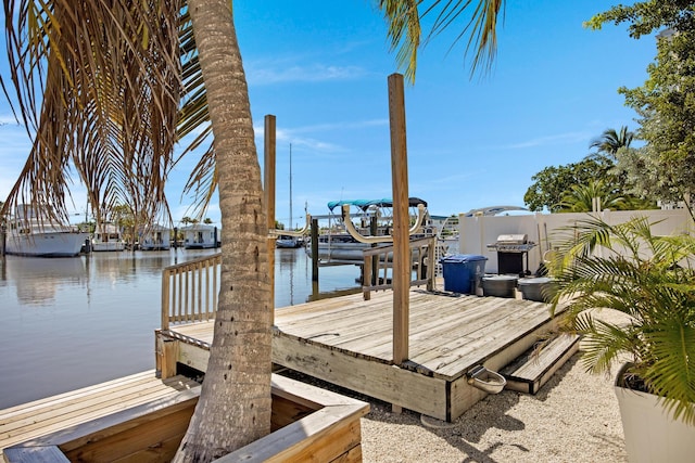 view of dock with a water view, boat lift, and fence