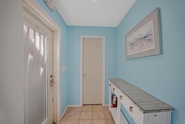 interior space with baseboards and light tile patterned floors