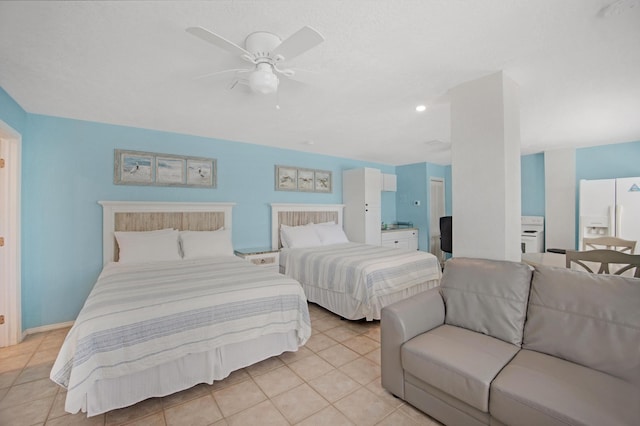 bedroom with light tile patterned floors, white refrigerator with ice dispenser, a ceiling fan, and baseboards