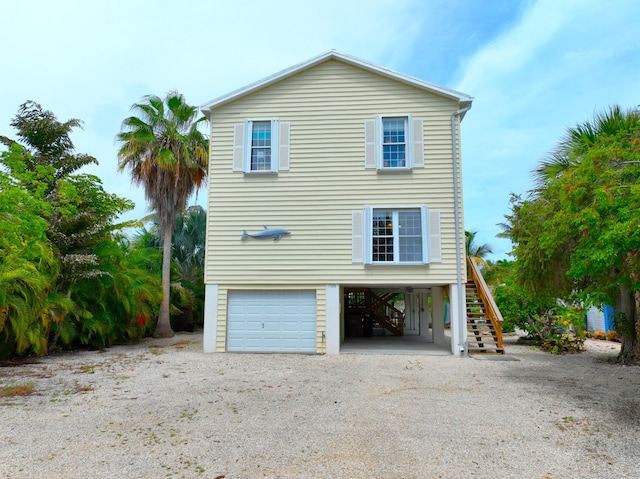 1590 Dolphin Dr, Marathon, FL 33050 - view of side of home featuring stairway, a garage, and dirt driveway