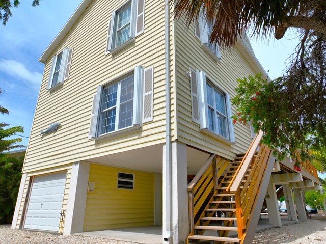 1590 Dolphin Dr, Marathon, FL 33050 - view of side of home with a carport, stairway, and a garage