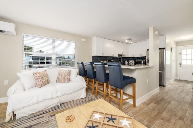 11282 2nd Ave, Ocean, Marathon, FL 33050 - living area with baseboards, an AC wall unit, and light wood finished floors