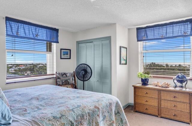 2000 Coco Plum Dr Unit 603, Marathon, FL 33050 - bedroom featuring light colored carpet, a textured ceiling, and a closet
