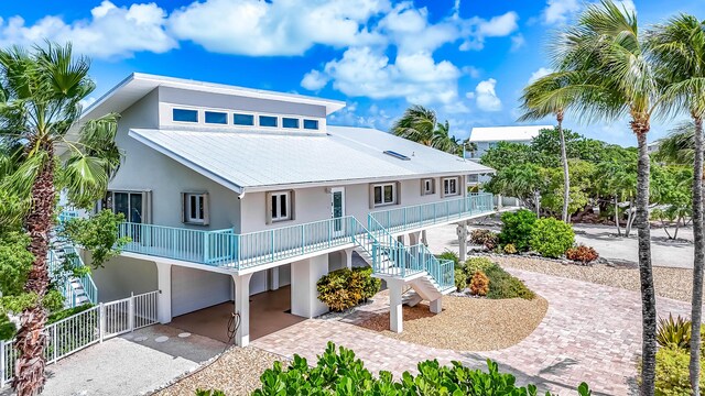 359 Stirrup Key Blvd, Marathon, FL 33050 - rear view of property featuring a carport, driveway, stucco siding, a porch, and stairs